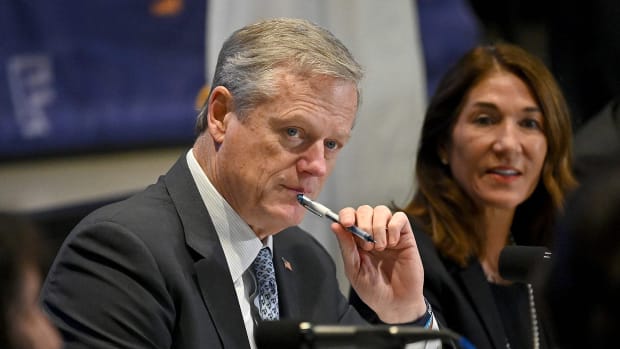 Charlie Baker listens to a presentation.